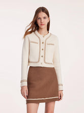 A lady wears a mini skirt and a tweed jacket.